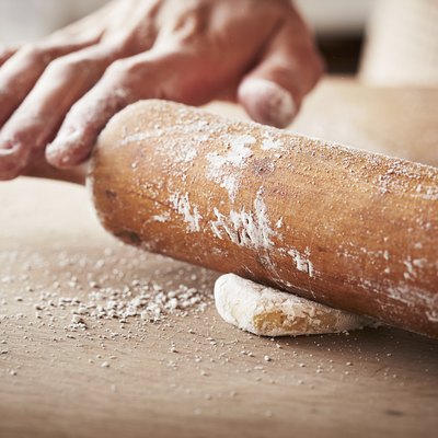 Hands baking dough with rolling pin