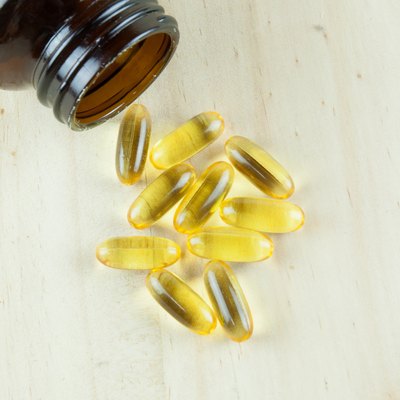 Fish Oil Arranged on wooden background with bottle laying down