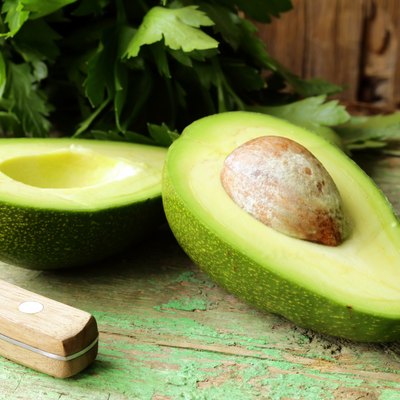 ripe avocado cut in half on a wooden table