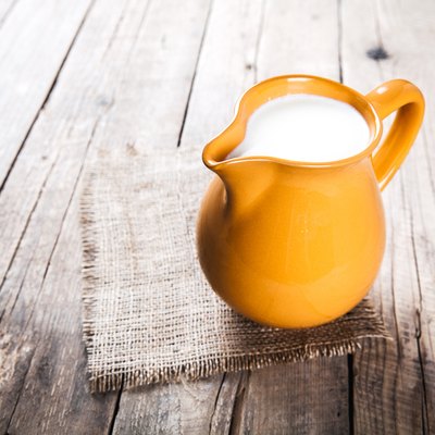 clay milk jug isolated on wooden background