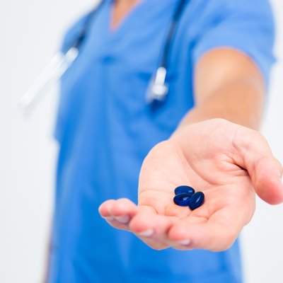 Male doctor holding pills
