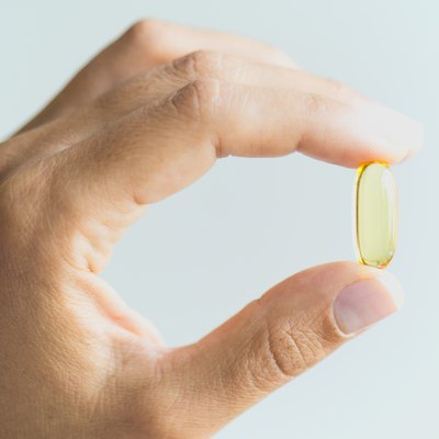 Woman Holding And Showing Omega 3 Capsule