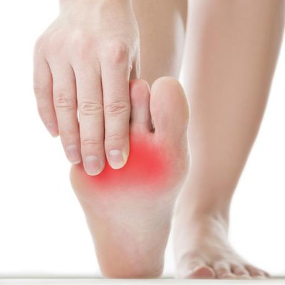 Pain in the foot. Massage of female feet. Pedicures. Isolated on white background.