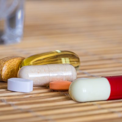 Pills and vitamins plus a glass of water