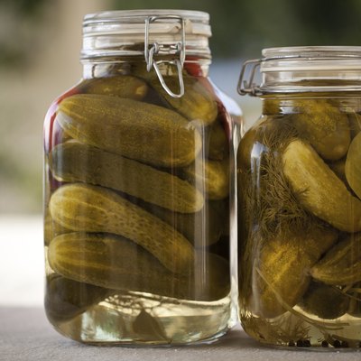 Glass jars of homemade canned cucumbers on the outdoors kitchen