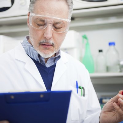 Doctor reading documents while holding a test tube