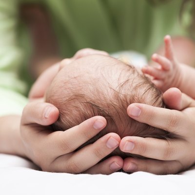 Cute sleeping newborn baby child on mother hands