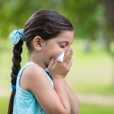 Little girl blowing his nose