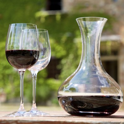 Red wine in a wine carafe and a two wine glasses in old vineyard