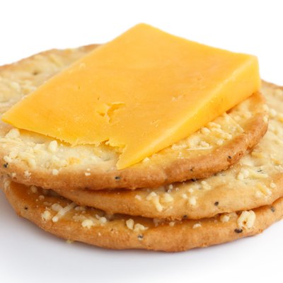 Three golden cheese crackers on white. With cheese.