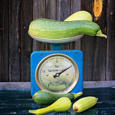 vintage scales courgettes on dark wooden background rustic farm products