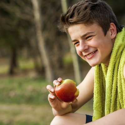 Teen eating apple after ecercise.