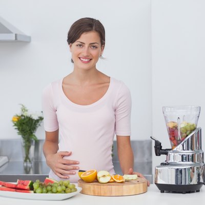 Pregnant woman making a fruit cocktail