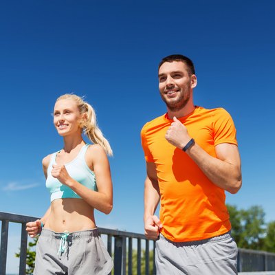 smiling couple running at summer seaside