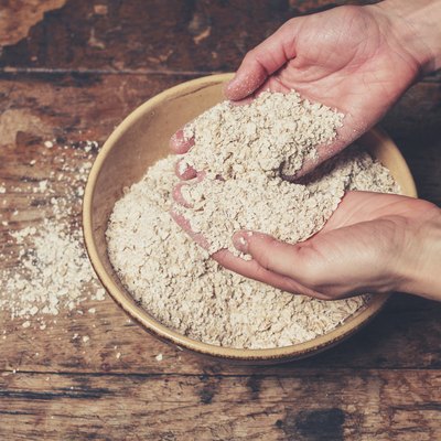 Hands mixing oats on table