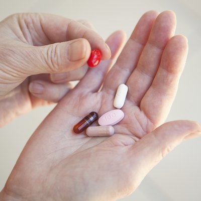 Close up of older person holding pills