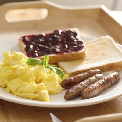 breakfast with scrambled eggs, sausage links and toast.