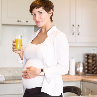 Pregnant woman having a glass of orange juice