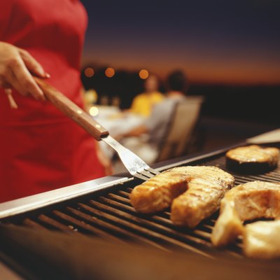 Woman barbecuing, close-up, mid section