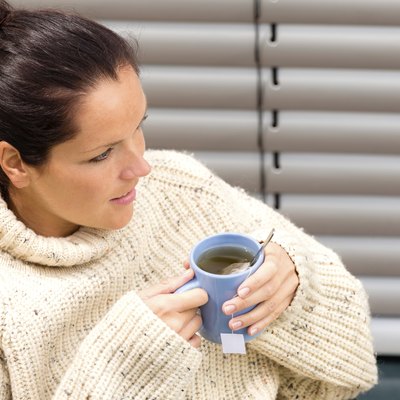 Woman drinking cup tea knitted sweater relaxing