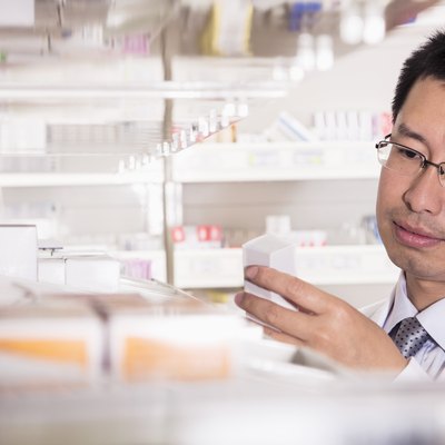 Pharmacist taking down and examining prescription medication in a pharmacy