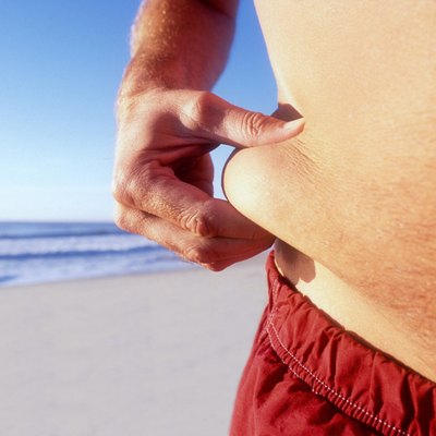 Man pinching fat on waist, mid section, close-up