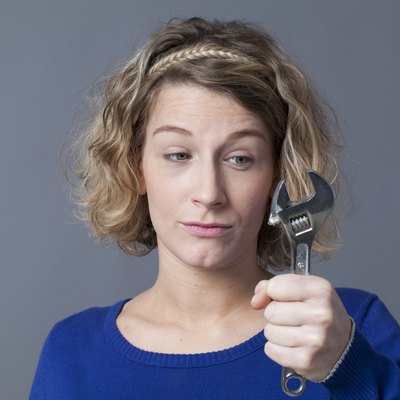 questioning 20s woman holding wrench for mechanics DIY