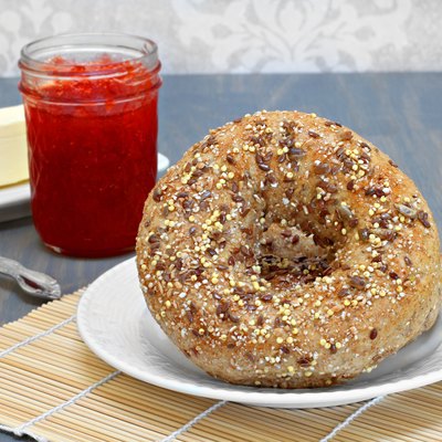 Whole grain bagels with jam and butter on the side.