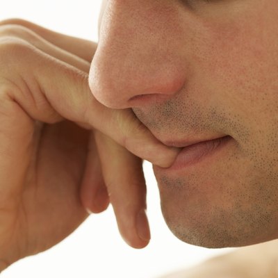 Young man biting nails, close-up