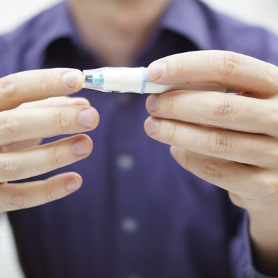 Closeup of young man using checking level of blood sugar