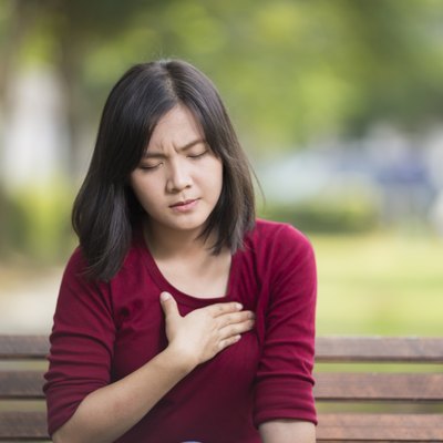 Woman Has Chest Pain Sitting on Bench at Park