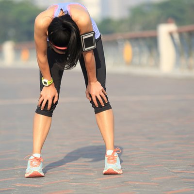 tired woman runner taking a rest after running hard
