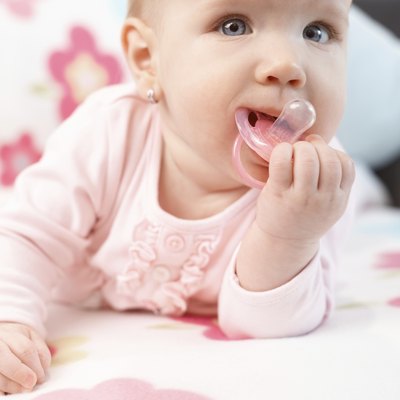 Beautiful baby girl playing with dummy