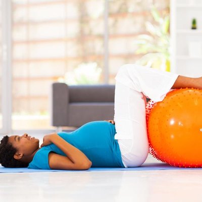 happy pregnant african woman workout on exercise mat at home