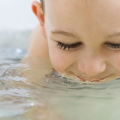 Happy little boy bathing in bathtub