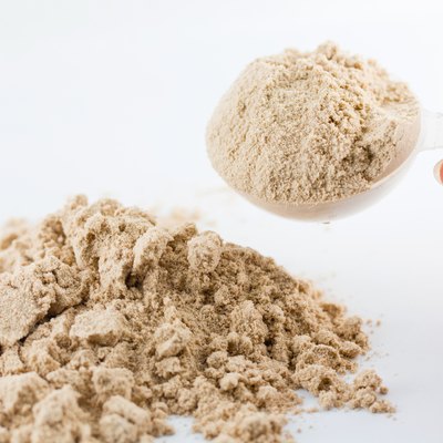 The hand raise a spoon measure Whey protein.