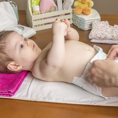 Mother changing diaper of adorable baby