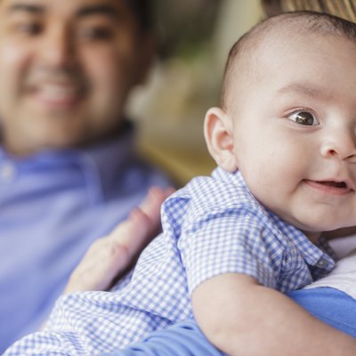 Happy Attractive Mixed Race Couple Burping Their Son