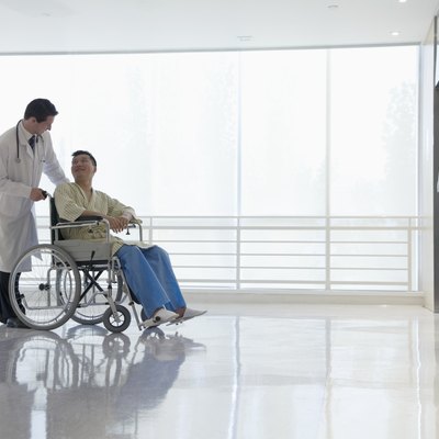Doctor pushing and assisting patient in the hospital, Beijing, China
