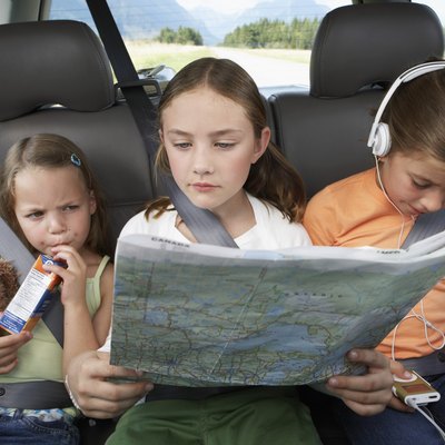 Three girls (6-8 years) sitting on rear seat of car during road trip