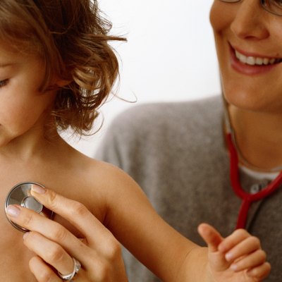 Doctor examining girl (18-24 months) using stethoscope