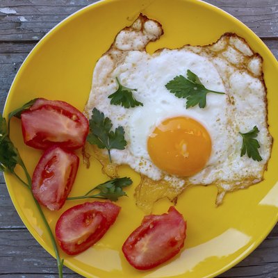 Scrambled eggs with tomato in a yellow plate