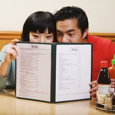 Asian couple reading menu at restaurant