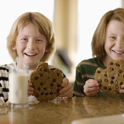 Boys having milk and cookies at table