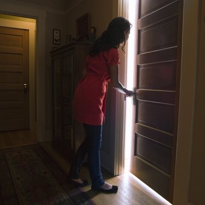 Woman opening bedroom door with light coming out
