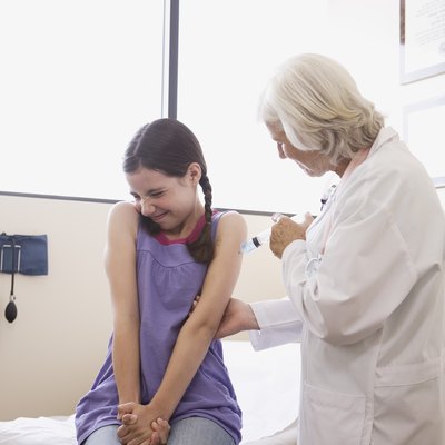 Doctor injecting preteen girl with needle
