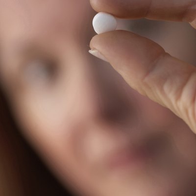 Close-up of a mature woman showing a pill