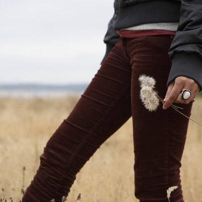 Teenage girl (15-17) carrying dandelion seed heads, mid section