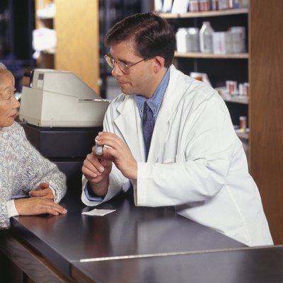 Senior woman talking with pharmacist in pharmacy