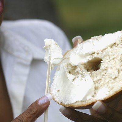 Close-up of a young woman holding a bagel